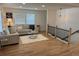 Bright living room showcases hardwood floors, a comfortable sofa, and a staircase with a black railing at 3866 S King St, Denver, CO 80236