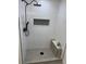 This walk-in shower features white tiled walls, a black shower head, and gray tile floors at 3866 S King St, Denver, CO 80236