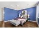 Serene bedroom with hardwood floors, blue walls, and plenty of natural light at 1964 S Leyden St, Denver, CO 80224