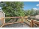Backyard deck with wood railing overlooks the yard and fences, with a large tree providing shade at 19954 E Dartmouth Ave, Aurora, CO 80013