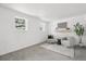 Bright living room featuring two chairs, minimalist decor, a large window, and neutral color palette at 19954 E Dartmouth Ave, Aurora, CO 80013