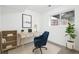 This home office features a modern desk, comfortable seating, neutral walls, a houseplant, and natural light at 19954 E Dartmouth Ave, Aurora, CO 80013