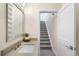 Stylish bathroom vanity with a modern sink and access to a carpeted staircase at 2600 S Sherman St, Denver, CO 80210