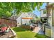 Backyard with artificial grass, stone patio, outdoor seating and mature landscaping at 3357 N Akron Ct, Denver, CO 80238