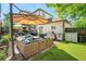 Backyard with artificial grass, stone patio, outdoor seating, grill, and landscaping at 3357 N Akron Ct, Denver, CO 80238