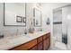 Bright bathroom features a double sink vanity with stone counters and framed mirrors at 3357 N Akron Ct, Denver, CO 80238