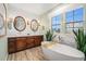 Elegant bathroom with a soaking tub, wood vanity, double sinks, and stone accents at 3357 N Akron Ct, Denver, CO 80238