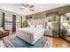Bright bedroom showcasing a plush bed, wood floors, and natural light from two large windows at 3357 N Akron Ct, Denver, CO 80238