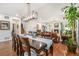 Elegant dining area with a long table, chandelier, and open view to the adjacent living room and kitchen at 3357 N Akron Ct, Denver, CO 80238