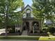 Welcoming exterior with stone detail, covered porch, manicured lawn, and mature landscaping at 3357 N Akron Ct, Denver, CO 80238