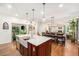 Open-concept kitchen with a large island, farmhouse sink, and seamless flow into the dining and living areas at 3357 N Akron Ct, Denver, CO 80238