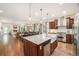Spacious open kitchen with a large island, stainless steel appliances, and hardwood floors, flowing into the dining area at 3357 N Akron Ct, Denver, CO 80238