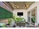 Relaxing covered patio features comfortable seating, tv, and privacy landscaping at 3357 N Akron Ct, Denver, CO 80238
