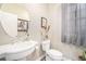 Charming powder room with pedestal sink, decorative mirror, and neutral color palette at 3357 N Akron Ct, Denver, CO 80238