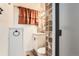 Powder room featuring a unique vanity and mirror with decorative tile work and sconce lighting at 8511 Essex Dr, Denver, CO 80229