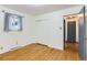 Bedroom showcases wood floors, white walls, closet, large window, and access to another room at 8511 Essex Dr, Denver, CO 80229