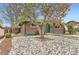 Charming brick home with a tree in the front yard and rock landscaping at 8511 Essex Dr, Denver, CO 80229