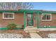 Home exterior featuring a brick facade, painted trim, and rock landscaping at 8511 Essex Dr, Denver, CO 80229