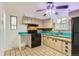 Well-lit kitchen with tile flooring, vintage cabinets, and gas range at 8511 Essex Dr, Denver, CO 80229