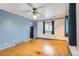 Hardwood living room with painted accent wall, bright windows, and ceiling fan at 8511 Essex Dr, Denver, CO 80229