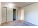 Well-lit bedroom with neutral carpeting and trim, showcasing spacious closets and entryways at 1530 S Quebec Way # 29, Denver, CO 80231