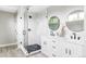 Modern bathroom featuring a glass-enclosed shower, dual vanities, and round mirrors at 1543 Glencoe St, Denver, CO 80220