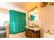 Unique bathroom featuring a colorful shower curtain, vintage vanity, and bright lighting at 919 Taylor Ln, Erie, CO 80516