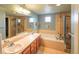 Bathroom featuring double sinks, a soaking tub, a tiled shower, and neutral-toned walls at 919 Taylor Ln, Erie, CO 80516
