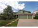 Charming green home with a three car attached garage and front lawn at 919 Taylor Ln, Erie, CO 80516