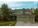Two-story green home featuring a three-car garage and a well-manicured lawn at 919 Taylor Ln, Erie, CO 80516