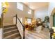 Inviting foyer with a staircase, chandelier, and view into the living room with lots of natural light at 919 Taylor Ln, Erie, CO 80516