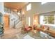 Bright foyer with stairs leading up and a view into the living room featuring high ceilings and large windows at 919 Taylor Ln, Erie, CO 80516
