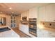 Modern kitchen with white cabinets, stainless appliances, a gas cooktop, and stylish backsplash at 919 Taylor Ln, Erie, CO 80516