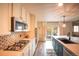 Modern kitchen featuring stainless steel appliances, dark island, and backyard access at 919 Taylor Ln, Erie, CO 80516