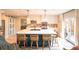 Bright kitchen featuring a large island with bar seating, modern lighting, stainless steel appliances and sliding barn doors at 919 Taylor Ln, Erie, CO 80516