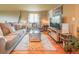 Cozy living room featuring comfortable sofas, a modern TV, and a vibrant rug on hardwood floors at 919 Taylor Ln, Erie, CO 80516