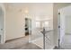 Hallway with neutral carpet and white railing leading to carpeted living area, with laundry room visible at 5423 Ben Park Cir, Parker, CO 80134