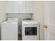 Laundry room with white washer and dryer set and white upper cabinets for plenty of storage space at 5423 Ben Park Cir, Parker, CO 80134