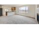 Open concept living and dining space featuring neutral walls, plush carpet, fireplace and a large window at 5423 Ben Park Cir, Parker, CO 80134