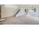 Spacious living room with a staircase, carpet flooring, and natural light from the large windows at 5423 Ben Park Cir, Parker, CO 80134