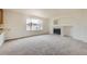 Bright living room features neutral walls, plush carpet, fireplace and a large window for abundant natural light at 5423 Ben Park Cir, Parker, CO 80134