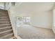 Bright living room featuring a staircase, carpet flooring, and large windows for natural light at 5423 Ben Park Cir, Parker, CO 80134