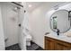 Modern bathroom with a black pebble floor shower and wood grain vanity with sink at 2764 S Reading Ct, Denver, CO 80231