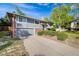 Charming two-story home with grey wood siding, brick accents, and a well-manicured front yard under clear blue skies at 2764 S Reading Ct, Denver, CO 80231