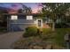 Charming two-story home with grey wood siding, brick accents, and a well-manicured front yard under a colorful sunset at 2764 S Reading Ct, Denver, CO 80231