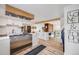 Bright, open kitchen boasts stainless steel appliances, white cabinets, and a seamless flow to the living area at 2764 S Reading Ct, Denver, CO 80231