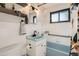 Vintage bathroom with a turquoise sink, black fixtures, white tile, and a retro design at 3224 Troy St, Aurora, CO 80011