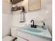 Charming bathroom features a unique turquoise sink, black fixtures, and is brightly lit at 3224 Troy St, Aurora, CO 80011