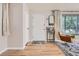 Inviting entryway with hardwood floors, a modern light fixture, comfortable chair and a decorative mirror at 3224 Troy St, Aurora, CO 80011