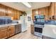 Well-lit kitchen features wooden cabinets, stainless steel appliances, and modern blue backsplash at 3224 Troy St, Aurora, CO 80011